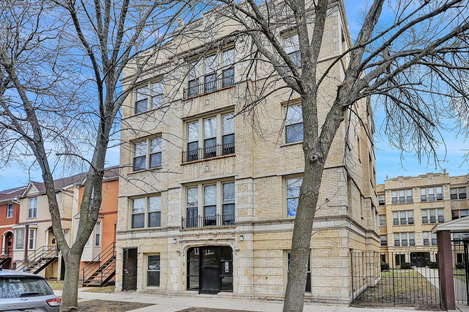 a brick apartment building with trees in front of it